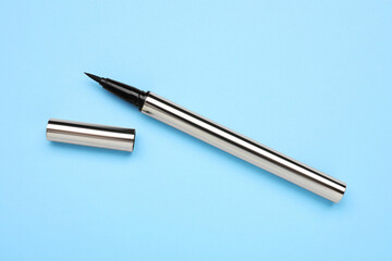 Eyeliner marker on light blue background, top view. Makeup product