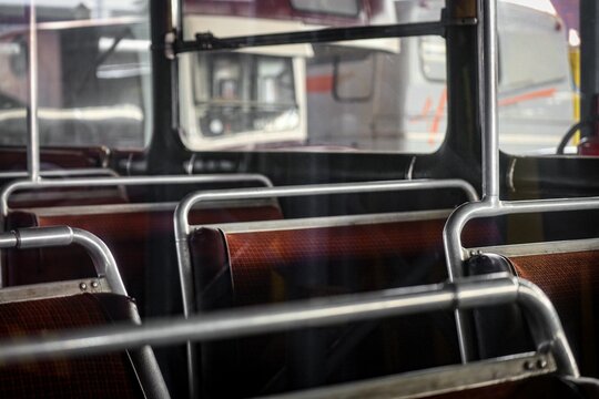 Vintage interior of an old abandoned school bus with red seats