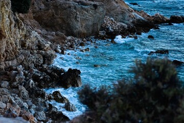 Beautiful shot of foamy sea waves covering a rocky coastline