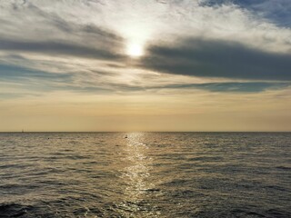 Minimalistic seascape with the bright sun rays reflecting on the water