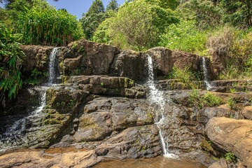 Scenic shot of small waterfalls flowing from rocks in a park