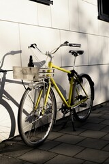 Fototapeta na wymiar Yellow vintage bicycle parked on the street on a sunny day