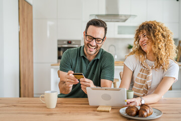 adult couple man and woman shopping online use laptop hold credit card