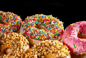 Closeup of colorful donuts isolated on a black background
