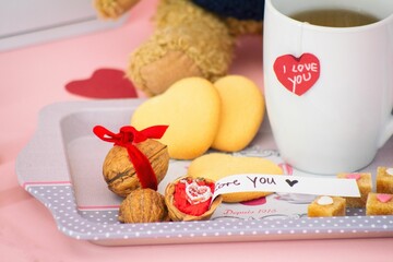 Closeup shot of a romantic necklace in a walnut as a surprise gift on a romantic platter with tea