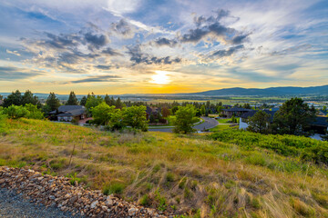 Fototapeta na wymiar Late afternoon sunset view from a hillside above a subdivision of homes of the cities of Liberty Lake, Spokane and Spokane Valley, Washington.