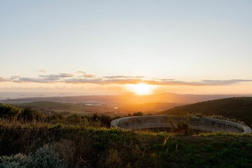 Beautiful view of hills and round stone structure under the clear sky during sunrise