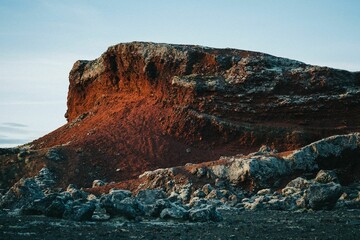 Fototapeta na wymiar Orange rock in Rauoholar with a blue sky in the background in Reykjavik, Iceland