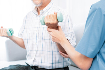 Contented senior patient doing physical therapy with the help of his caregiver. Senior physical...