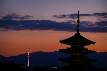 Silhouette of the Chureito Pagoda with an illuminated tower and golden sunrise in the background