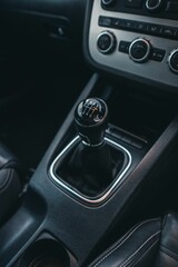 Fototapeta na wymiar Vertical closeup shot of a manual transmission in black car interior