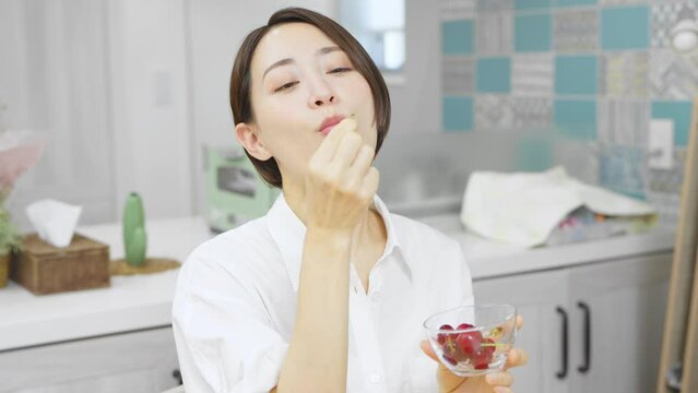 サクランボを食べる若い女性　飲食イメージ	
