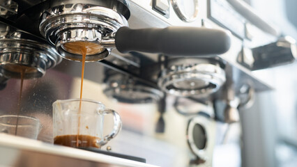 Coffee machine making espresso in a coffee shop, shallow depth of field