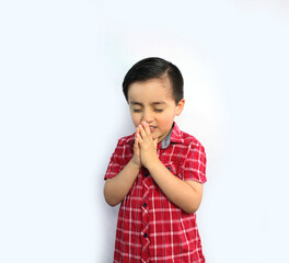 child with hands joined in prayer,  eyes closed, head inclined, three-quarter view, 5 year-old, red plaid shirt, straight black hair, latin boy, Mexican, light skin, pink cheeks, white background