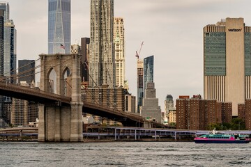 Brooklyn Bridge with the skyscrapers and urban buildings in the background at sunset, New York, USA