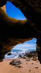 Vertical shot of a beautiful seascape seen from a cave located on the shore of a beach