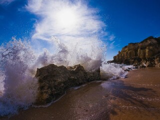 Scenic view of strong sea waves hitting the rocky shore of the beach