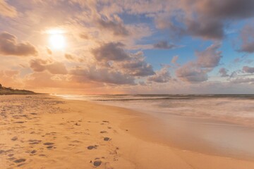 Fototapeta na wymiar Beautiful shot of a sandy beach under a cloudy sky during a sunset