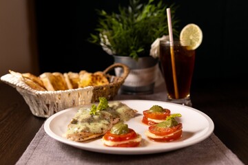 a plate of food with tomatoes on a white table cloth