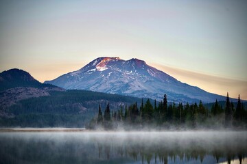 Foggy Sparks Lake at sunrise reflecting a snowy mountain and clear sky background