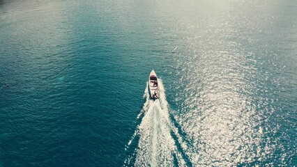 Aerial video of a white boat rides on the sea on a sunny day