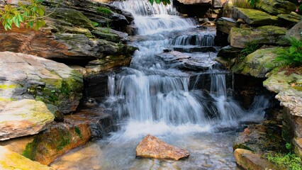 Long exposure water flowing over a rocky surface on a sunny day