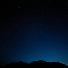 Scenic view of a dark night sky full of stars above a silhouette of a mountain range