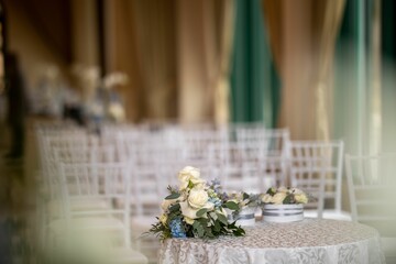 Interior of wedding styling and decor table with flowers, chairs blurred background