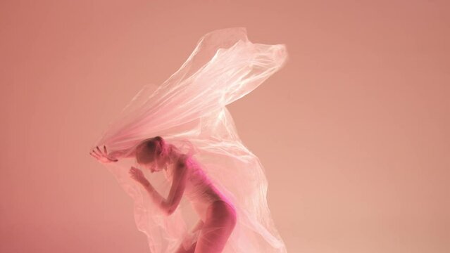 Inner world. Tenderness and grace. Young girl, ballerina dancing with transparent fabric against gradient studio background in neon light. Classical art, dance, beauty, inspiration, creativity concept