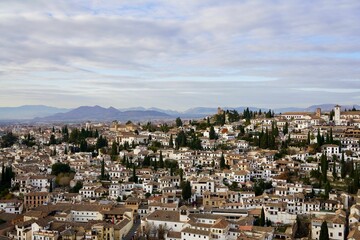 Fototapeta premium Cityscape with an array of white buildings surrounded by lush mountains in the background