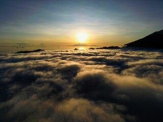 Aerial shot of a stunning landscape featuring a breathtaking sunrise with majestic mountains. © Stefan572/Wirestock Creators
