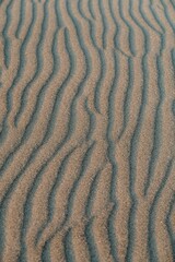 Aerial shot of a beach with thin lines of sand running through it