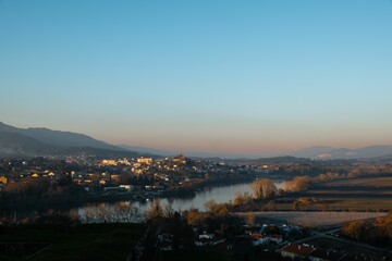 Scenic view of a valley from the top of a hill, overlooking a cityscape and body of water