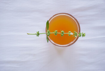 Top view of refreshing iced peach tea with a branch of basil flower                 