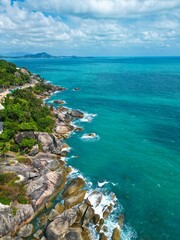 Fototapeta premium Aerial view of an expansive ocean contrasted by the deep blue sky and white billowy clouds