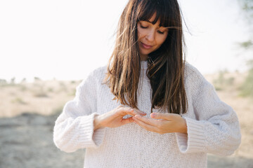 Woman in a sweater playing with hands