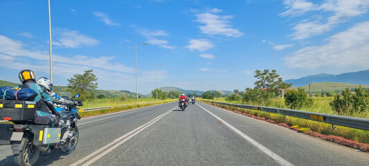 motorbikes, motorbikes traveling in team  on asphalt  street in bright sunny spring day greece