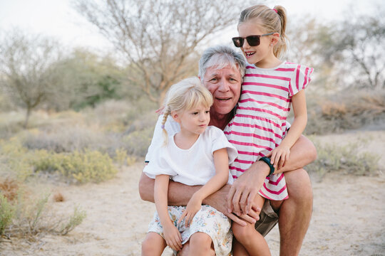 Grandfather with granddaughters in the nature