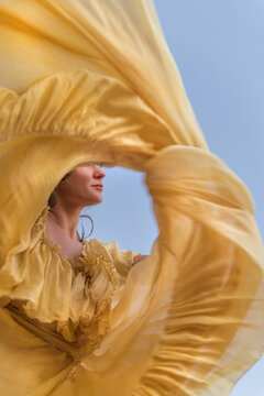 woman twirls flowy yellow silk flamenco dress 