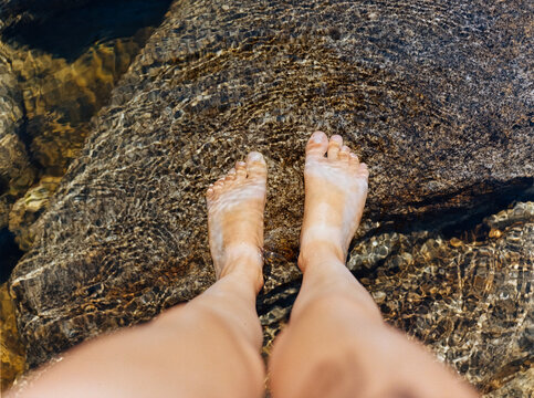 Feet Standing on Rocks in the Water