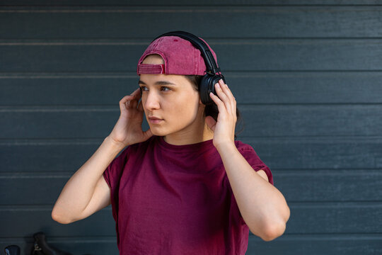 the girl looks to the side and straightens the headphones