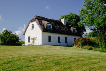 Fototapeta na wymiar A traditional irish cottage on top of a lush green field
