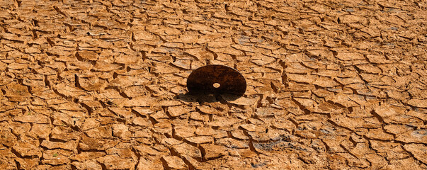 Cracked ground with old vinyl records embedded: The concept of technological obsolescence over time.