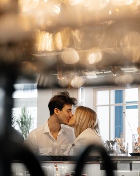 Romantic couple kissing in bar through bokhe
