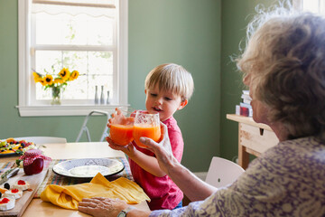 Grandmother and grandson toast with papaya juice