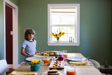 Boy setting up table for breakfast