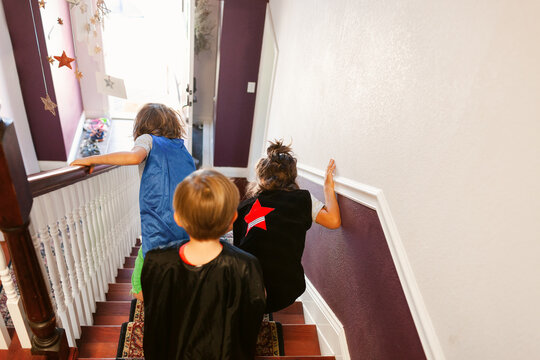 Children in capes going down stairs