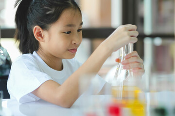 Little child with learning science class in school laboratory