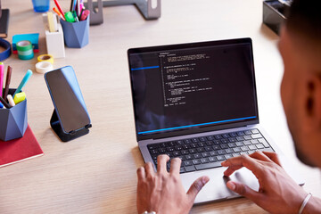 Cropped image of programmer using notebook for work