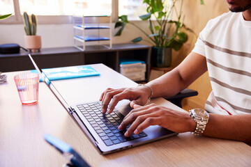 Unrecognizable employee browsing computer in office